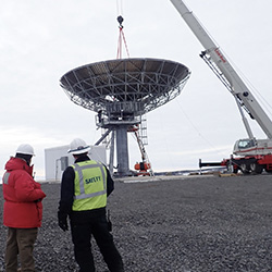 Staff oversee the construction of the new Ross Island Earth Station (RIES) antenna at McMurdo Station, Antarctica.