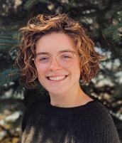 Woman with curly hair and glasses