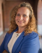 Woman with curly hair and a blue jacket