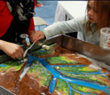 Child and adult working with clay and water at the USA Science and Engineering Festival