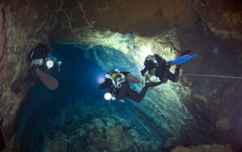 Cave divers diving in a submarine lava tube cave in the Canary Islands