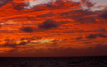 Sunset paints the sky over IODP drillship <em>Joides Resolution</em>