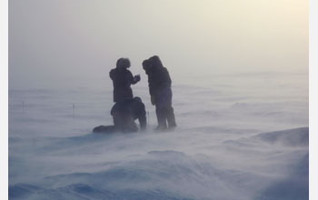 Researcher records snow/ice interface temperatures out on frozen surface of Elson Lagoon,Alaska