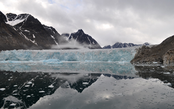 A glacier calving icebergs into a fjord in the Norwegian archipelago of Svalbard, Norway