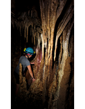 Climbing through decorated cave chamber called Fairy City deep within Clearwater Connection cave