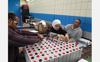 Students assemble a battery pack for an electric roadster project