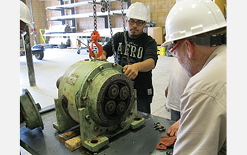 A student examines a wind turbine gear box