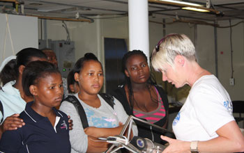 Photo of oceanographer Lisa Beal showing schoolchildren a current meter.