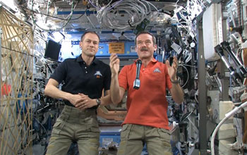 astronauts on space station with microphone