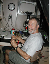 Photo of oceanographer Edward Carpenter looking at diatoms through a microscope.