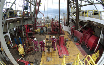 Photo of scientists and engineers working on the rig floor aboard the drill ship JOIDES Resolution.