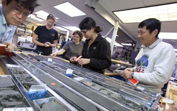 Photo of geologists sampling a sediment core.