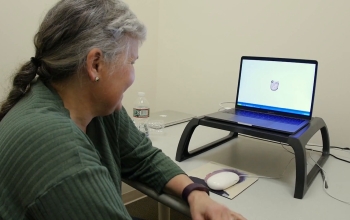 woman looking at computer screen with a face on it