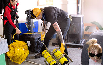 Photo of three people hauling a sensor from the ocean.