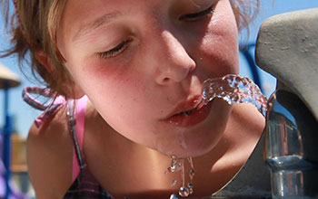 Child drinking water from water fountain