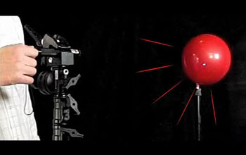 a high-powered laser shined on a red balloon.