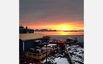 The sun sets behind a small chain of islands near Palmer Station