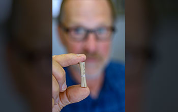 Ornithologist David Steadman holds <em>Caracara creightoni</em> femur