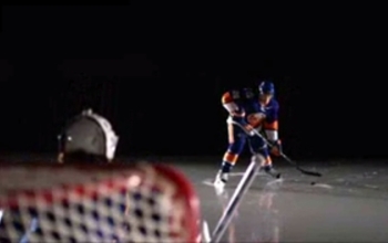 Hockey player hitting a slapshot toward goalie
