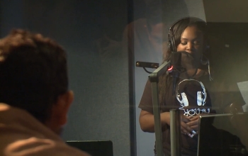 student in radio booth talking into microphone