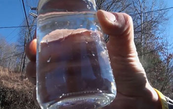 Hand holding jar of water