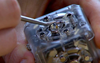 Close up of hand using tool on modular robot cube