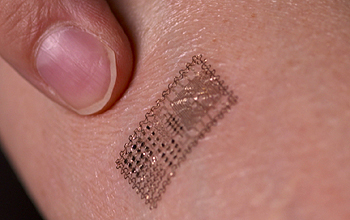 Finger pointing to electronic tattoo on skin