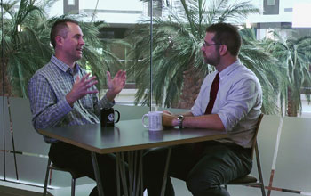 two men talking at a table