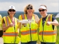 three women standing holding a drone