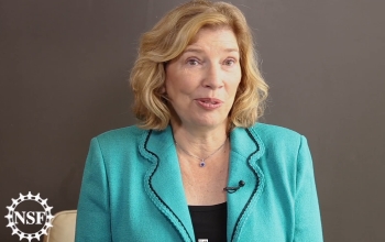 woman sitting against a plain background